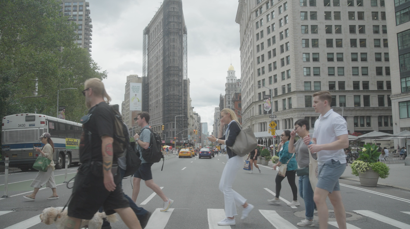 A team navigating a busy New York street beside the Flatiron Building